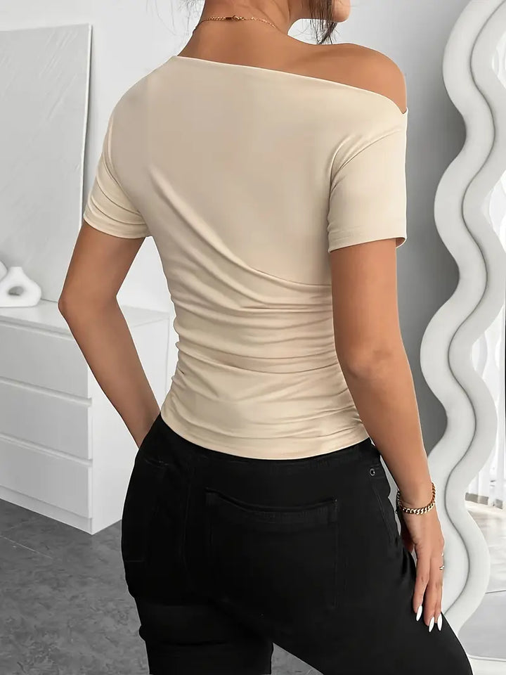 Short top with short sleeves, featuring irregular pleating and a slim-fit cut